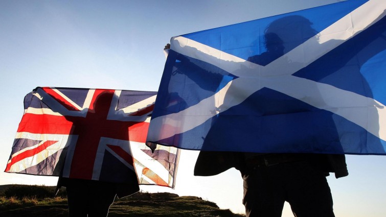 Zwei Personen halten die Flaggen Großbritanniens und Schottlands. ( picture alliance / empics