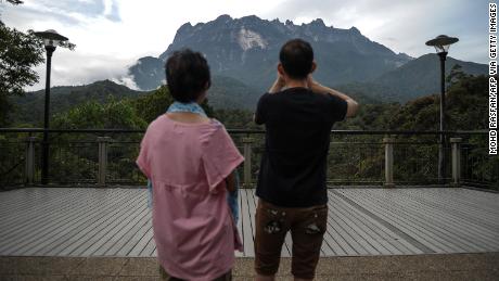 Tourists take pictures of Mount Kinabalu in Malaysia in 2015.