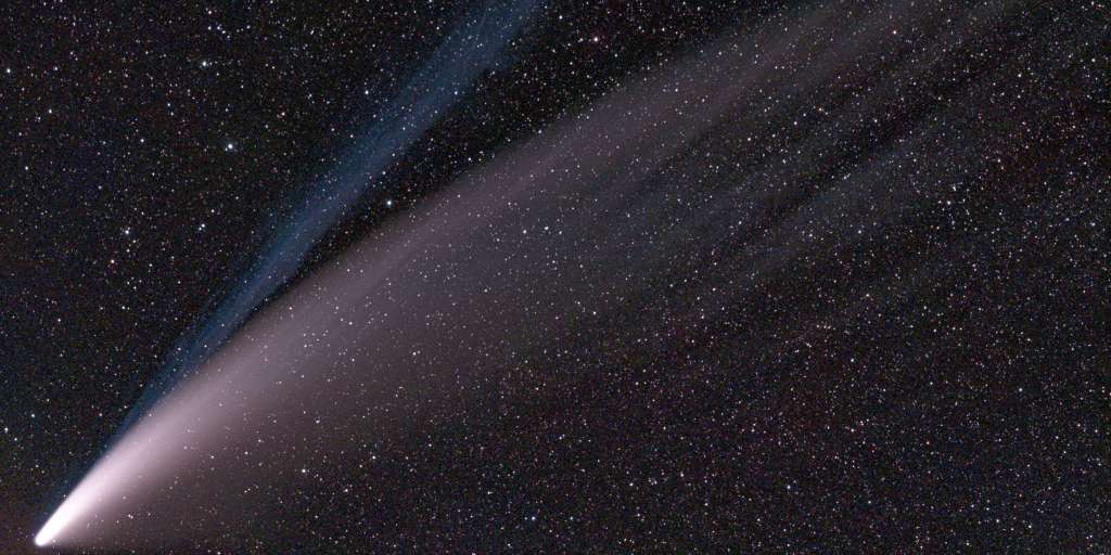 A comet flies across the Earth in the vastness of space
