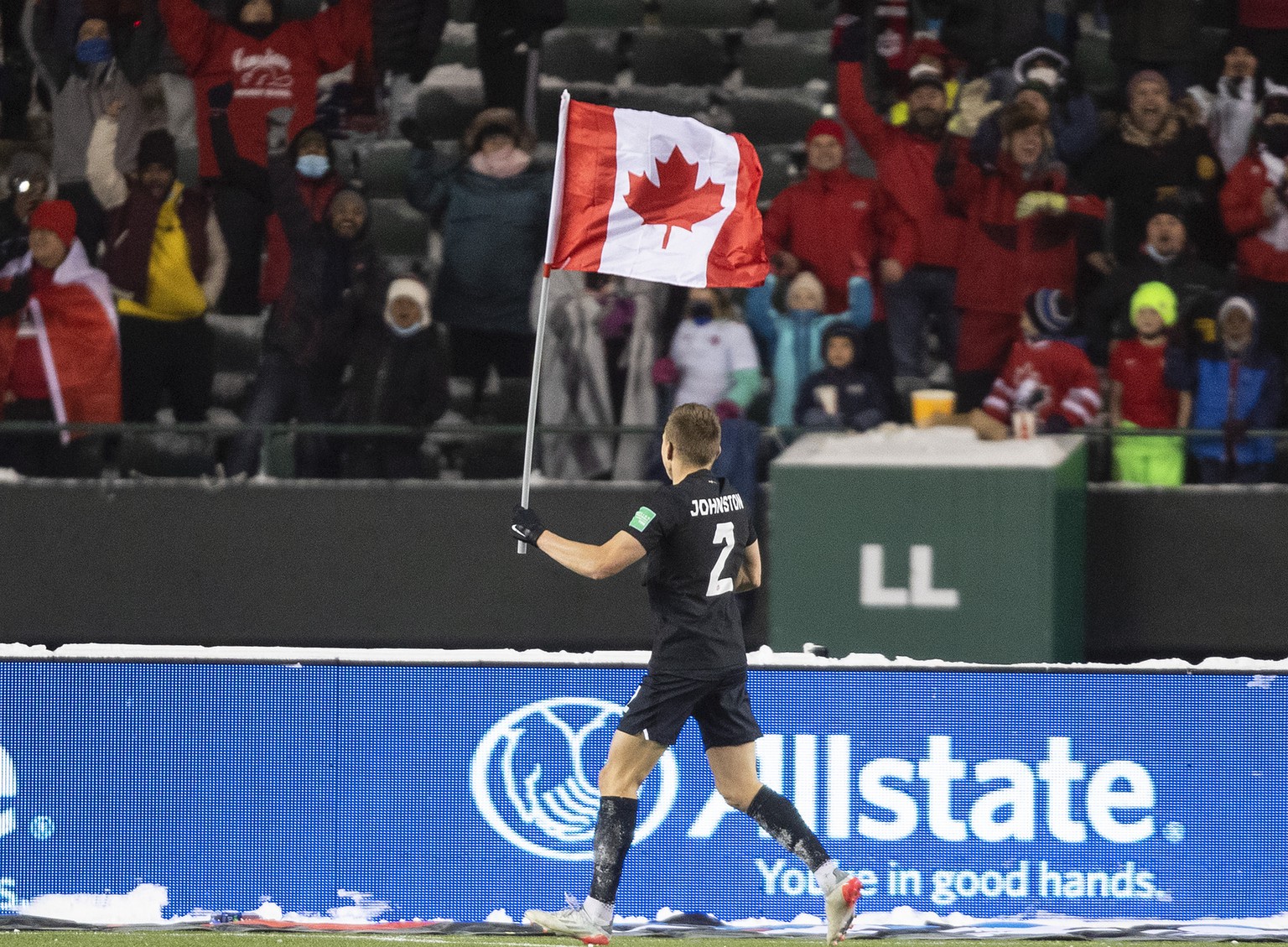 Alistair Johnston cheers on the Canadian flag.