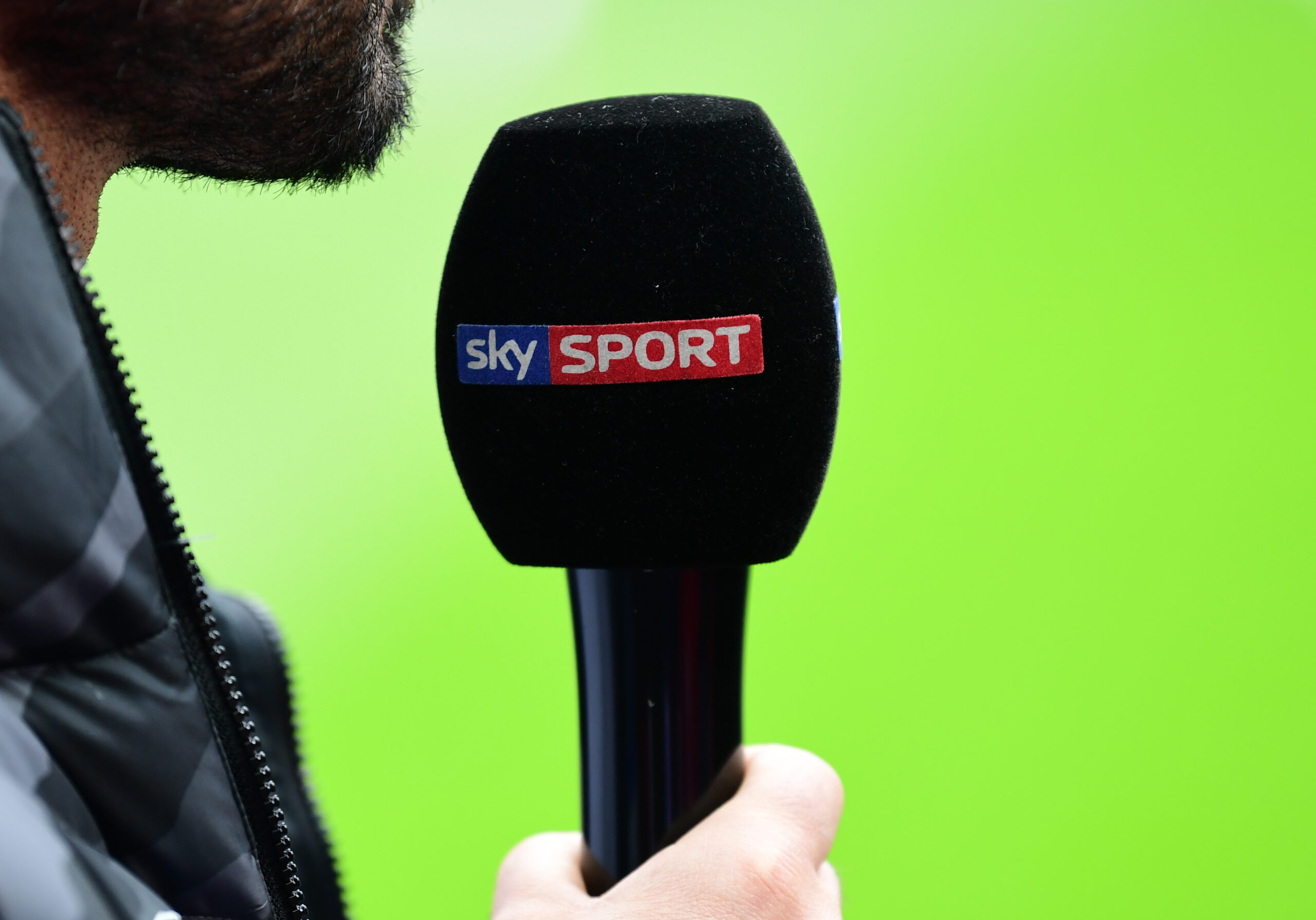 Symbolbild: Mensch spricht in Mikrofon mit „Sky Sport“-Beschriftung