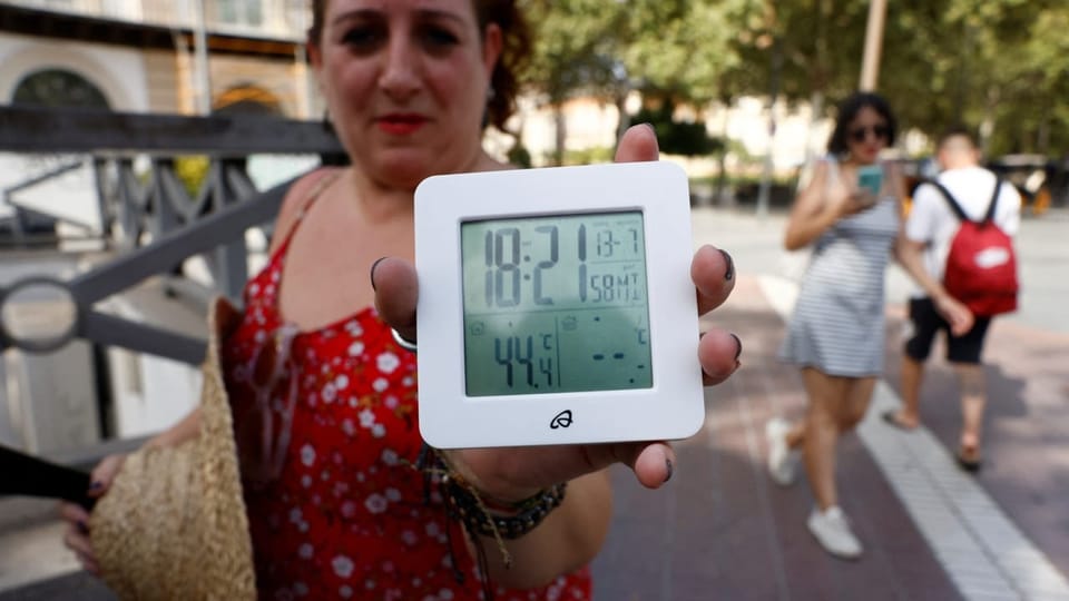 Woman showing a thermometer to the camera