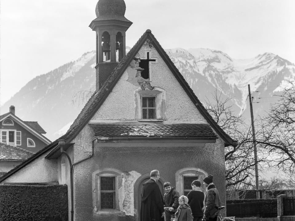 A priest with his children in front of the ruined church of Saint Antonia in Sarnen.