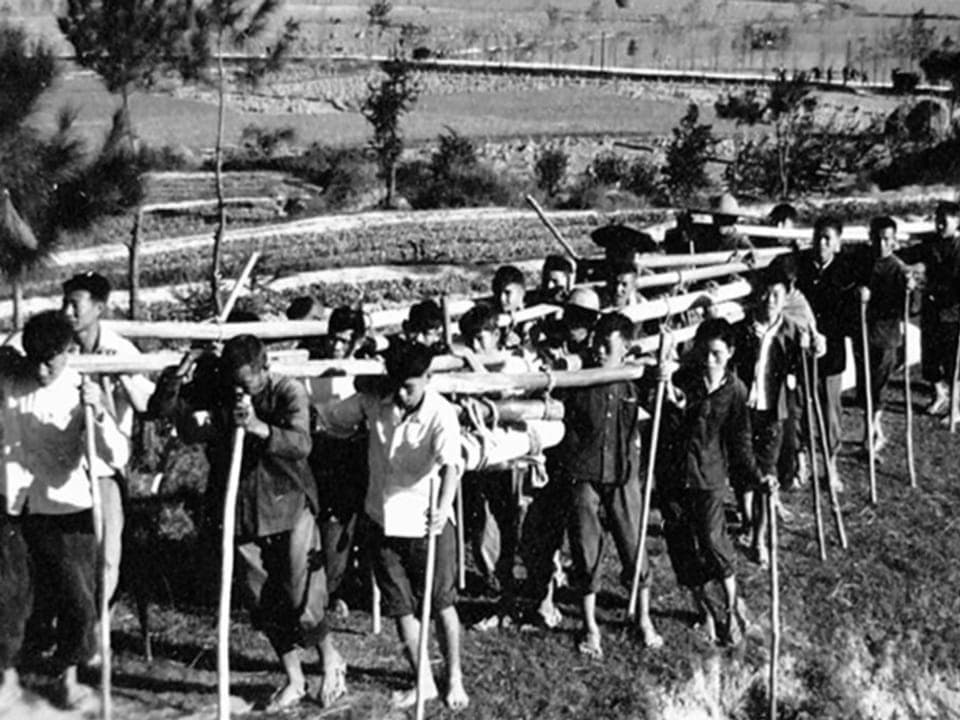 Agriculture workers carrying bamboo poles in the 1960s. 